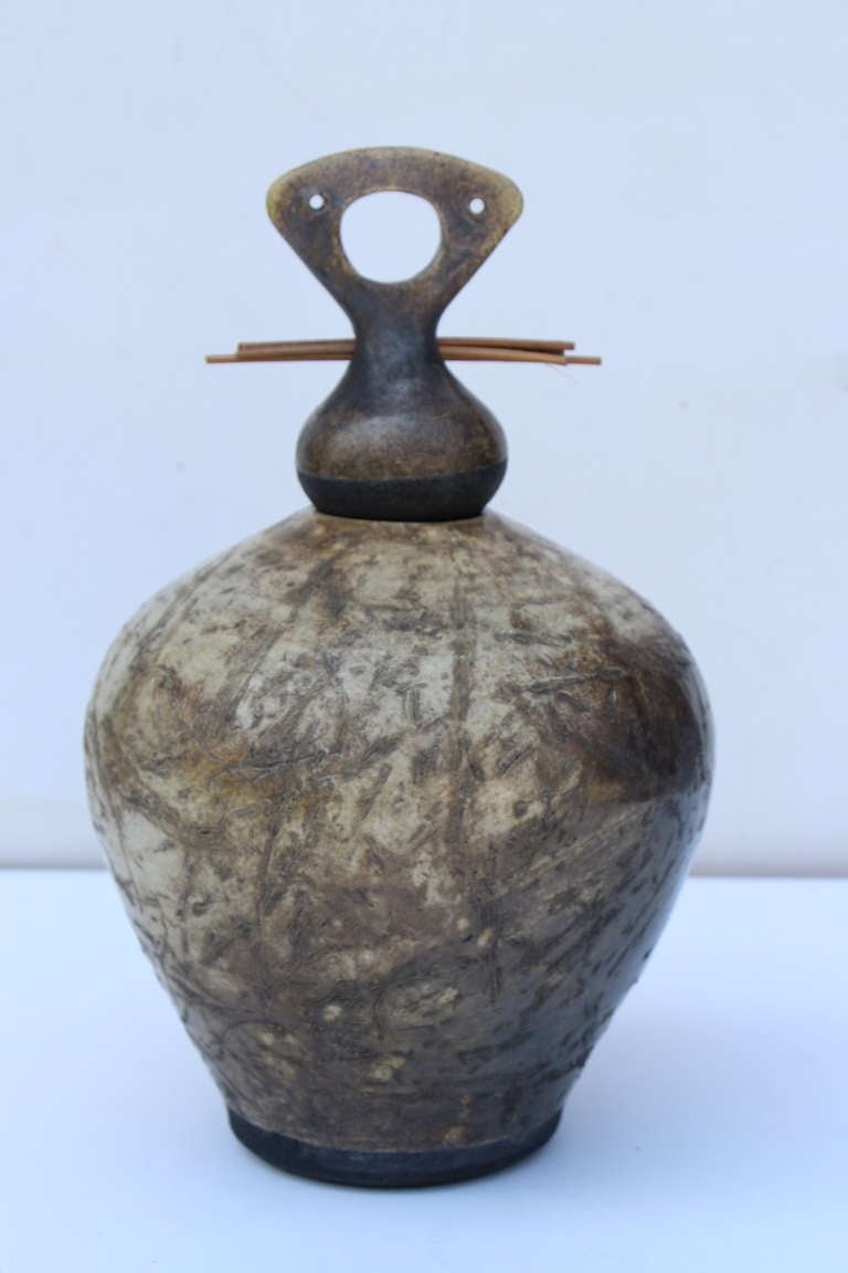 A quite stunning piece of pottery by the noted potter Lew Ayres done in the Raku style. The paper pictured will accompany the vessel which gives a background on Mr. Ayres and a brief description of the raku process.