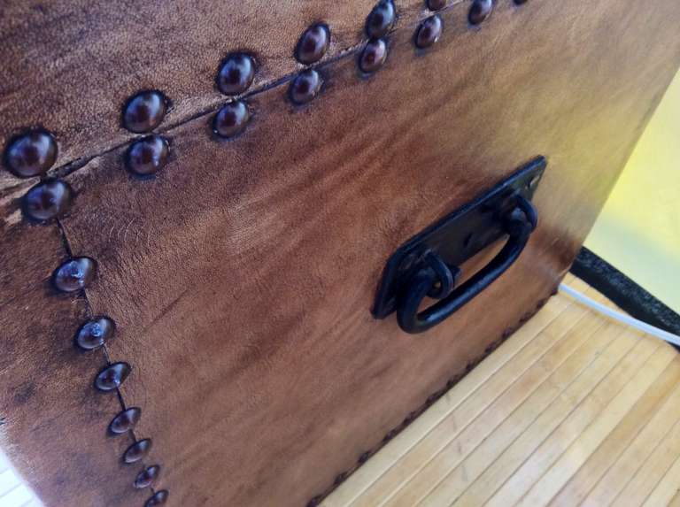 A nice leather covered trunk with nailhead trim. Appears old probably 19th century. The interior is coverd in a blip use paper while the outside bears a brass plaque on top with initials.  Would make a great coffee table. The leather appears to have