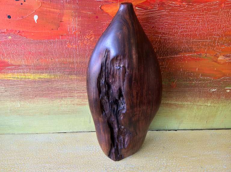 A great turned vessel out of ironwood by the noted woodworker Bob Womack. This piece may have lost its neck at some point, because there is a hole on top, or it may simply be where the lathe was attached. 
A brief bio from the artist's website