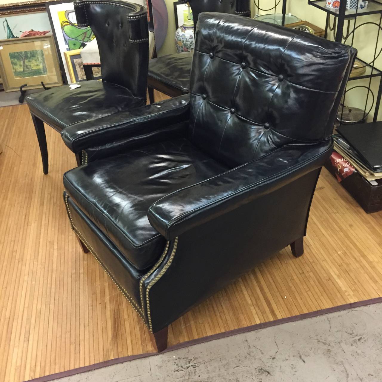 A very nice patent leather lounge chair or miniature wing chair. It features nailhead trim and wood legs. It is in original condition with some splits to the leather seat and abrasions to the leather which are pictured. There are some nicks and