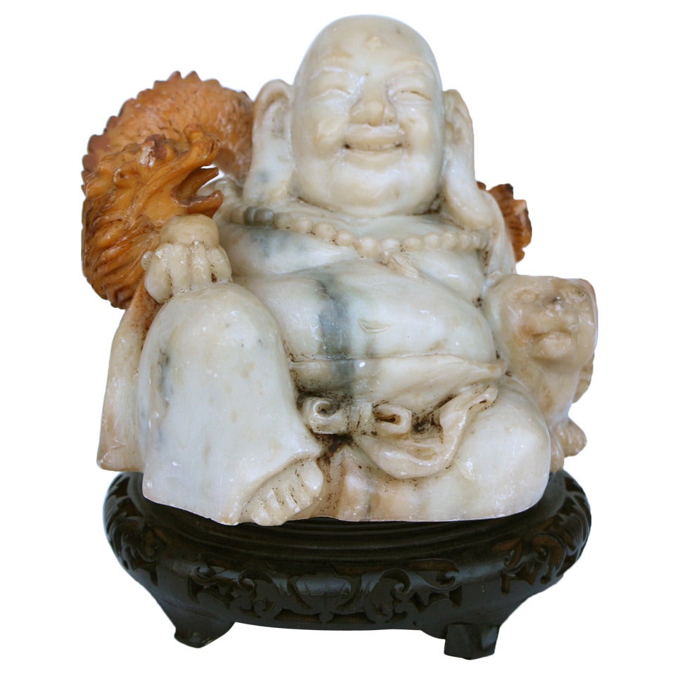 Asian carving of a smiling Buddha with cat and dragon