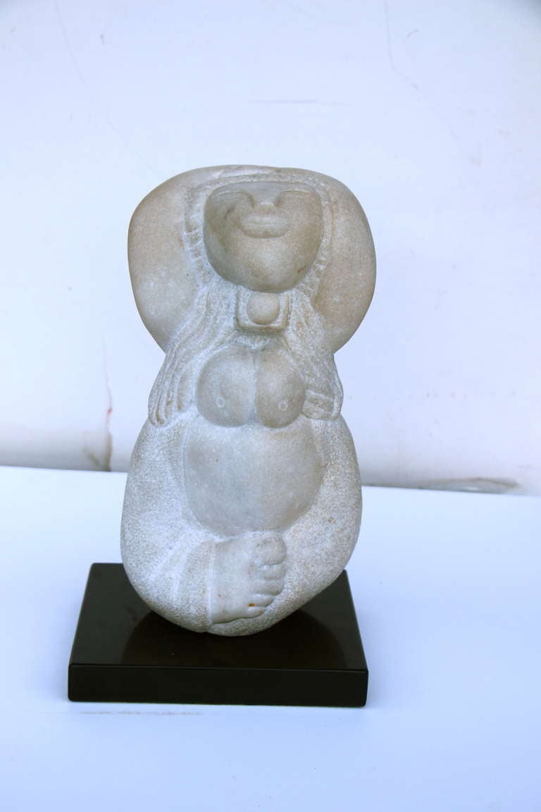 A really wonderful stone carving on a slate or marble base. It as a unique monogram on it and it is dated 1979. The sculpture is not permanently affixed to the base but rests nicely in the hole of the base. The figure looks vaguely Inuit to me or