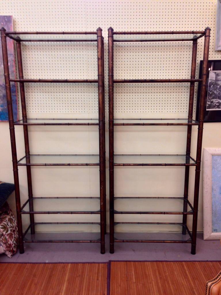 A pair of patinated metal faux bamboo etageres. Each has six glass shelves.