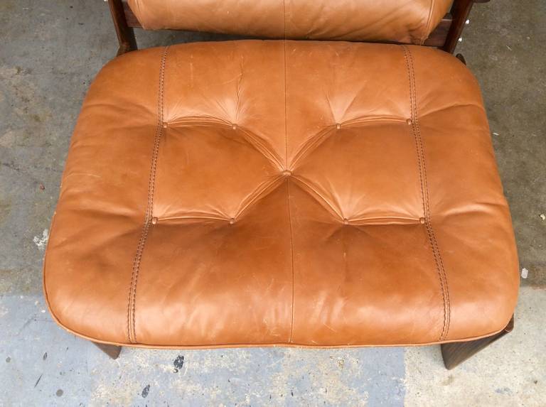 A nice Perceval Lafer rosewood and leather lounge chair and ottoman. It is in it's original condition with wear to the leather and wood although it is pretty good considering it's age. We had it professionally tightened and retouched. 
Measurements