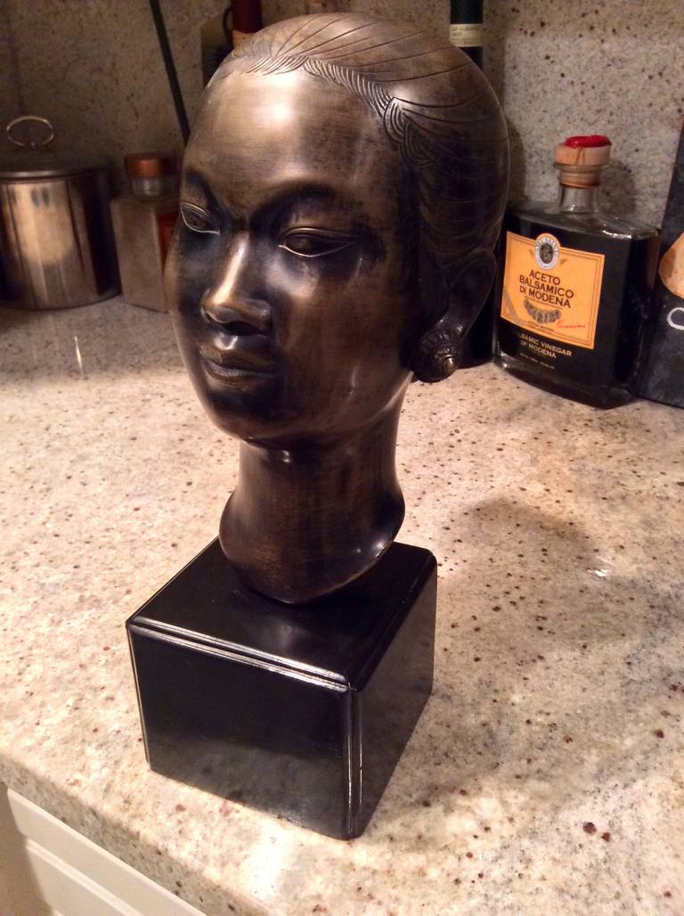 An exquisite example of an Asaian bronze art this bust of a woman is signed with a monogram on the back. It is mounted to a black wood base.