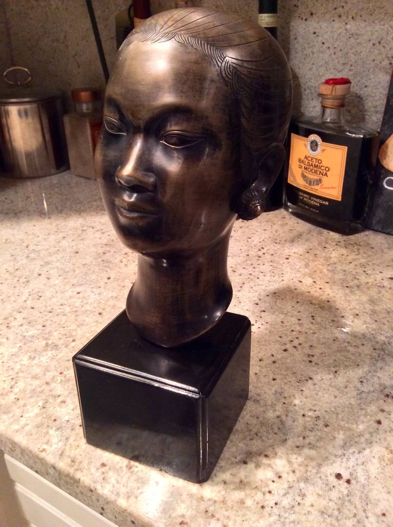 Un esempio squisito di arte bronzea asaiana, questo busto di donna è firmato con un monogramma sul retro. È montato su una base in legno nero.