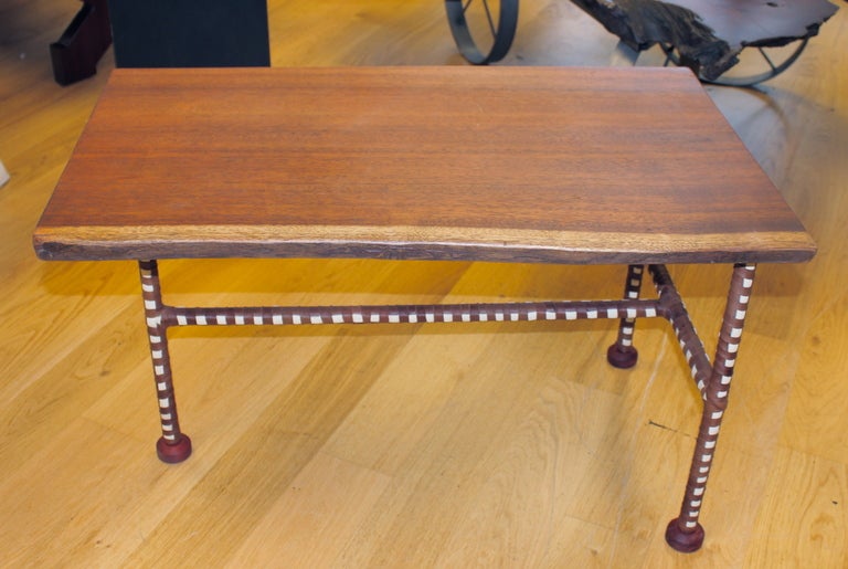 A beautiful piece of old mahogany with sap wood free edge with two color strips of leather wrapped around the legs. We had found this beautiful table with legs that were too far gone to save. We have added these legs which have leather strips in two