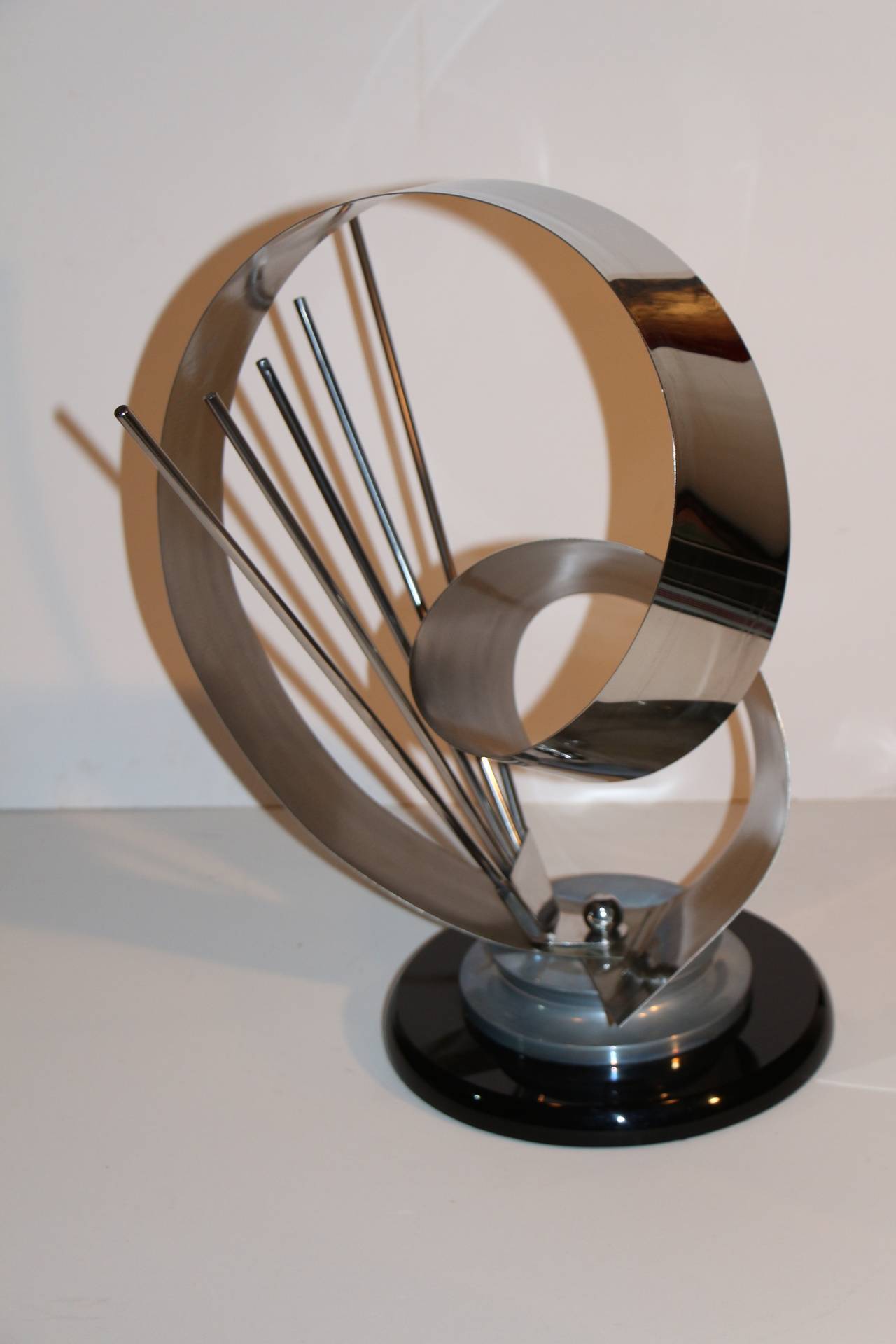 A signed Shlomi Haziza metal sculpture. It is etched with the artist's signature and also bears his firm's label. Nice piece with a bit of Kinetic energy to it, as the ribbon part moves around.