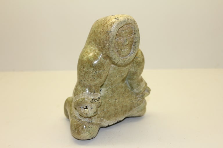An Inuit carving of a man signed on the base. It  appears to be a hardstone not the typical soapstone carvings. Great color and striations.The man is approx 6 inches tall and approx 5x3.5 inches in dimension. It is signed on the base. Age