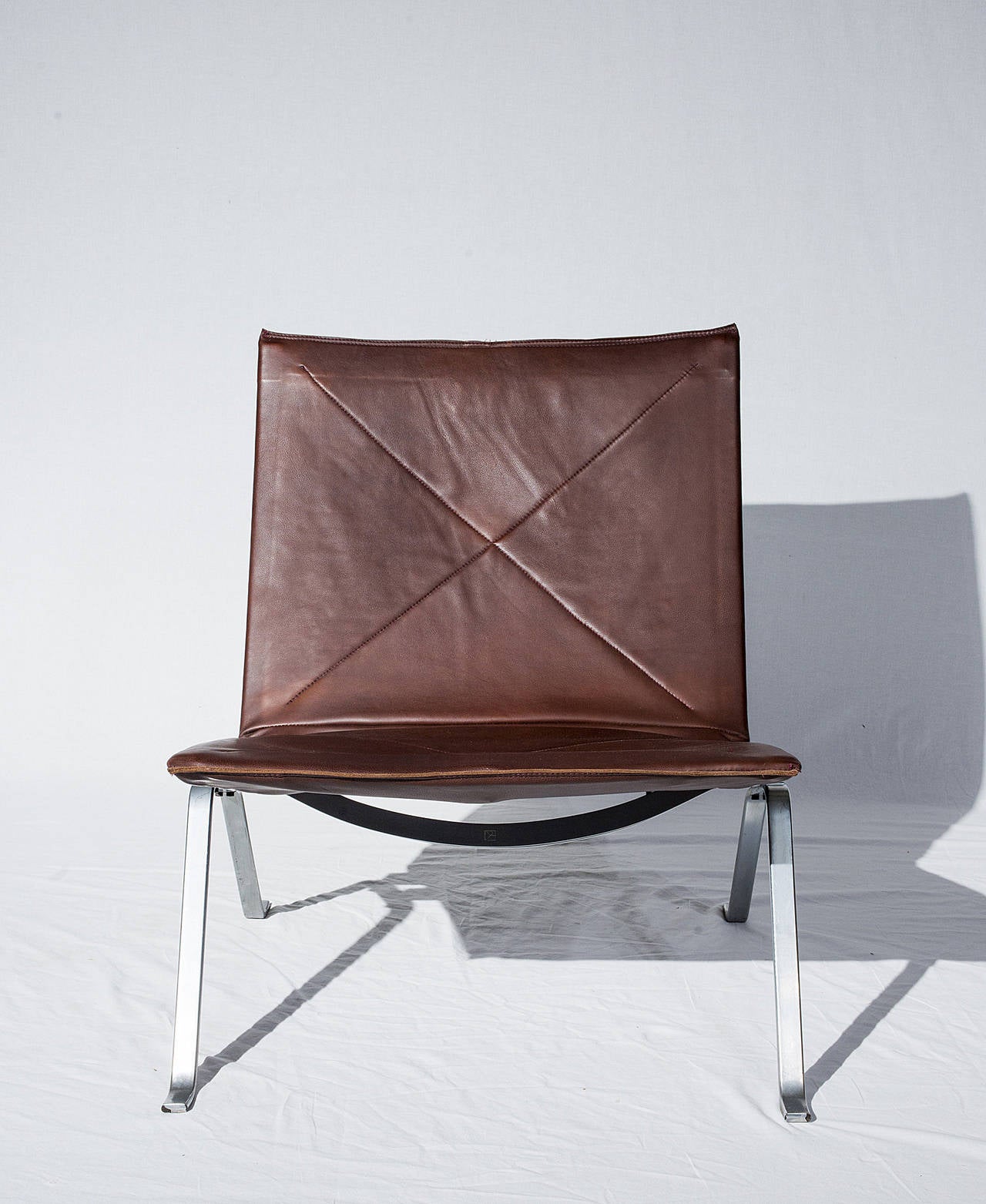 Pair of Poul Kjaerholm lounge chairs designed in 1956 and produced
by E Kold Christensen. Chairs are signed with E Kold Christensen's mark.
Chairs have been reupholstered in new brown leather.