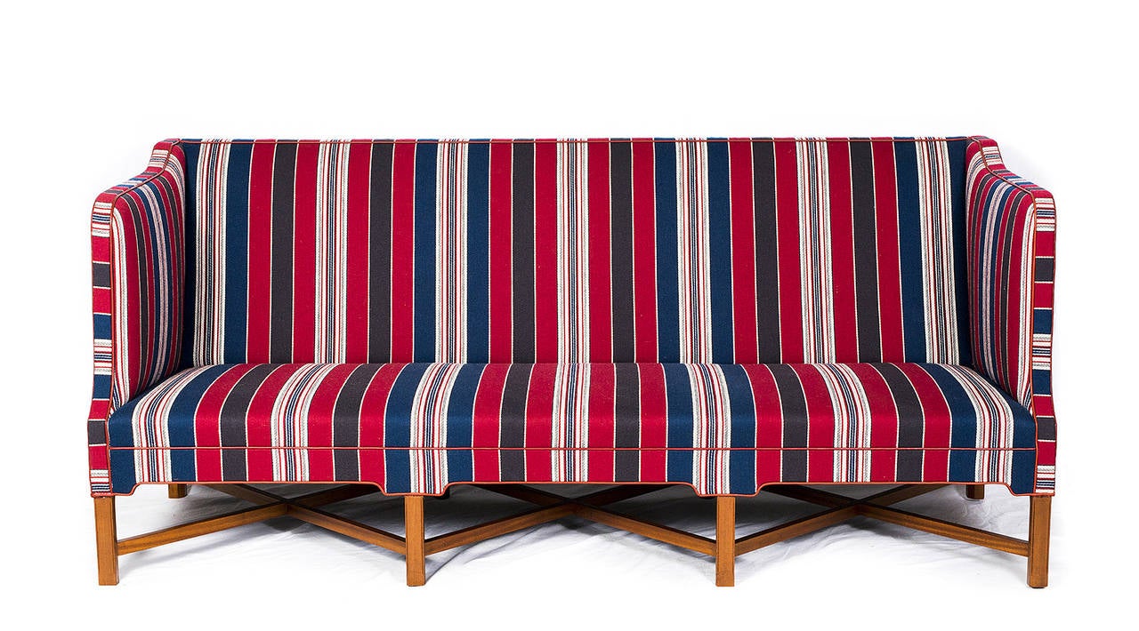 Kaare Klint X-base sofa, Model #4118. Designed in 1930 and produced by Rud Rasmussen. Wool fabric with red leather piping. Cuban mahogany 
base.   Store formerly known as ARTFUL DODGER INC