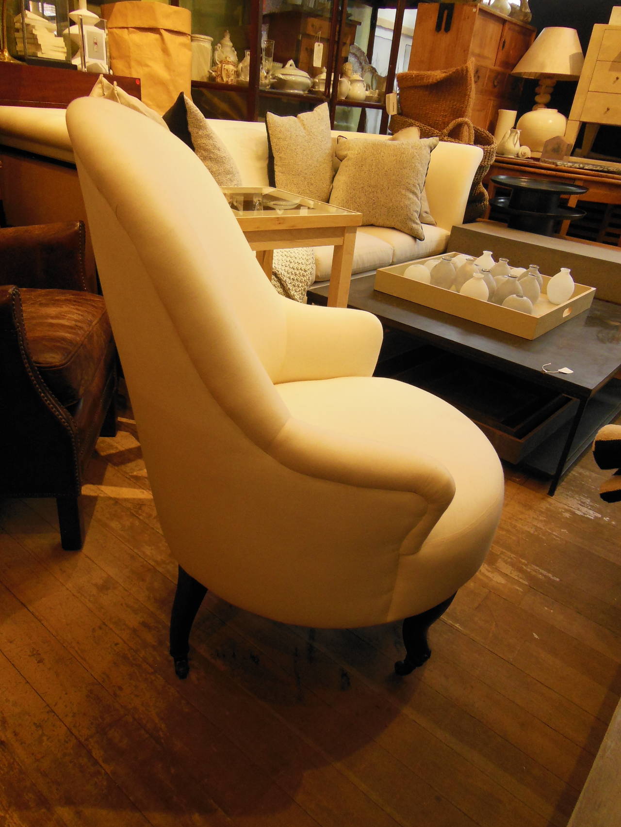 unique armchair with 3 front legs newly redone in ivory muslin