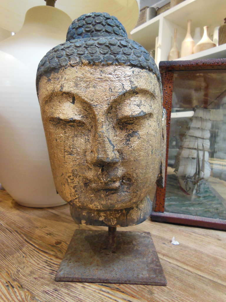 Cast iron buddha with gilding on stand.