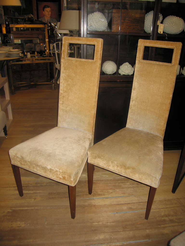a pair of fun tall chairs with cutouts on tapered legs