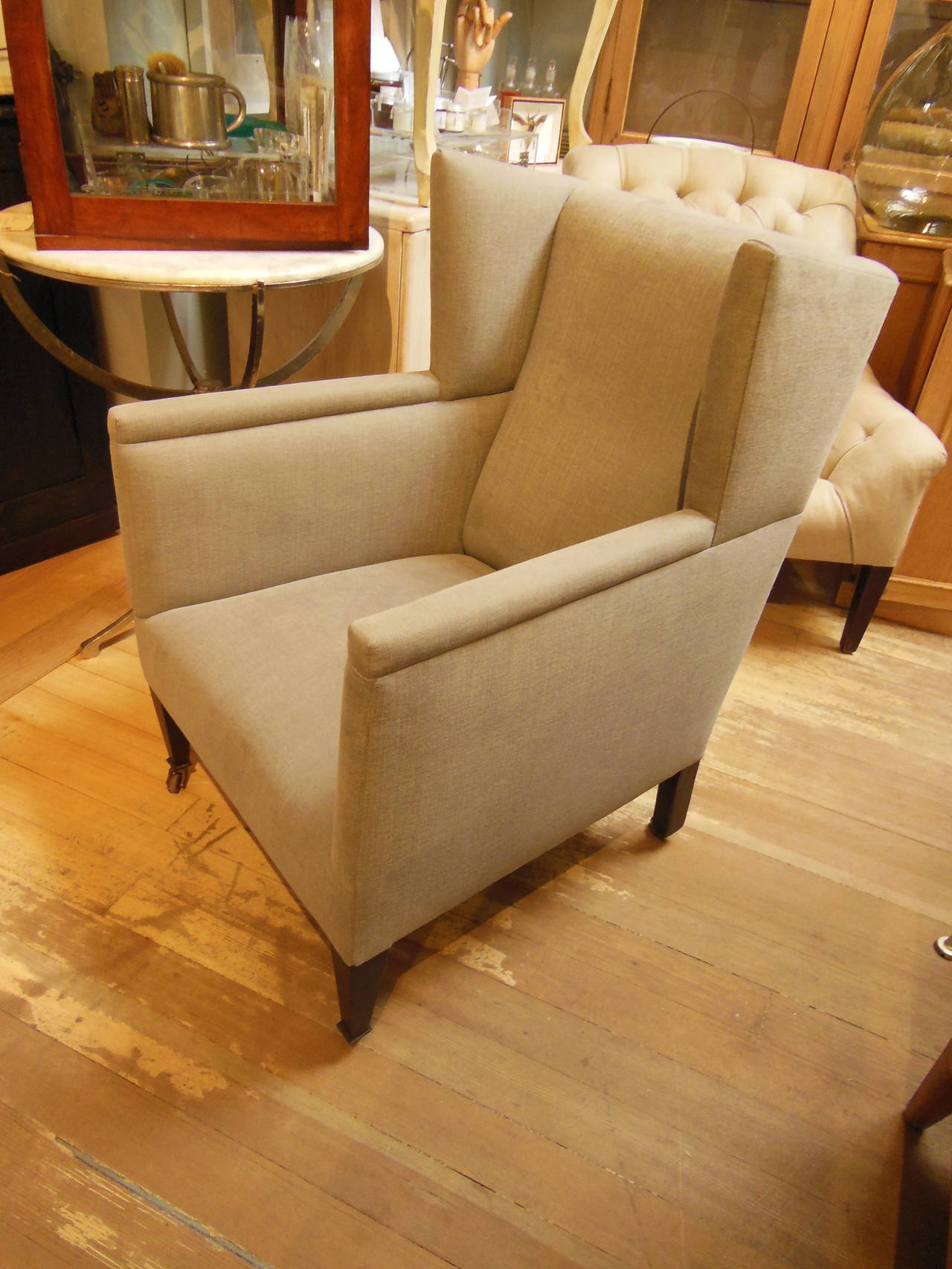 a small vintage wing chair reupholstered in Romo linen on tapered legs with casters