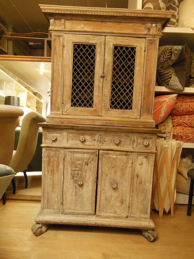 A diminutive cabinet in two parts with metalwork inset panels on doors and carved feet