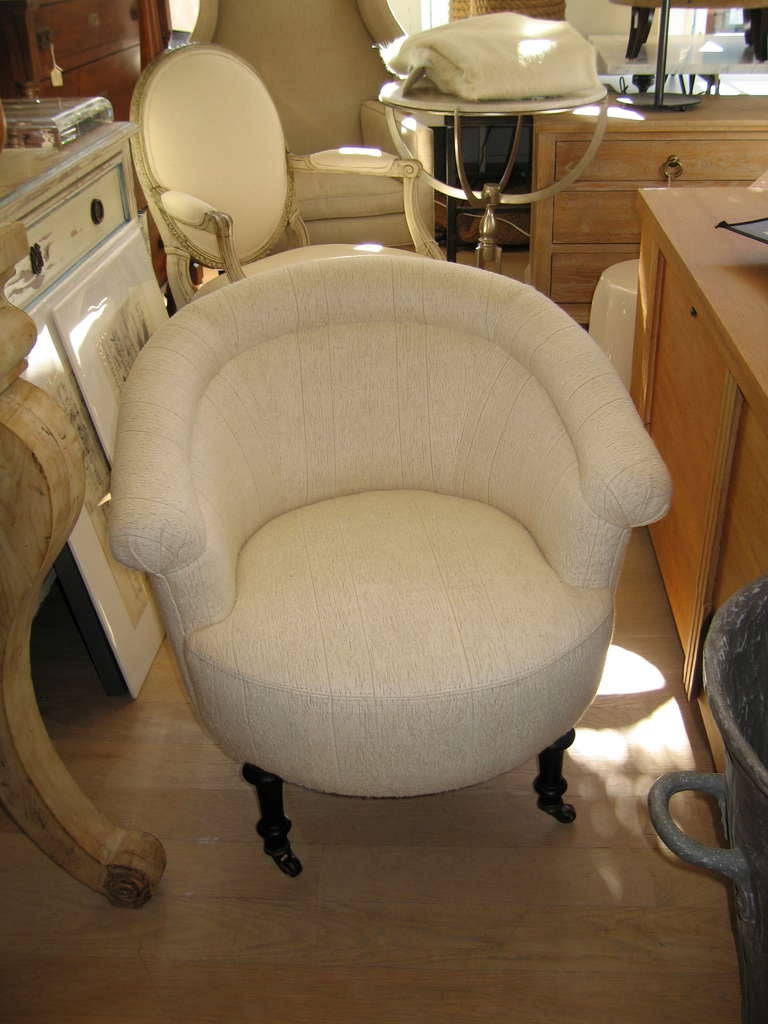 a small armchair newly reupholstered  with turned legs on casters