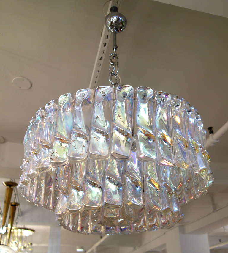 An Italian Mid-Century  Mazzega Murano chandelier comprised of three rows of thick, shaped handblown iridescent glass rectangles hanging from a professionally polished chrome frame with thirteen Edison sockets newly wired for the American market.