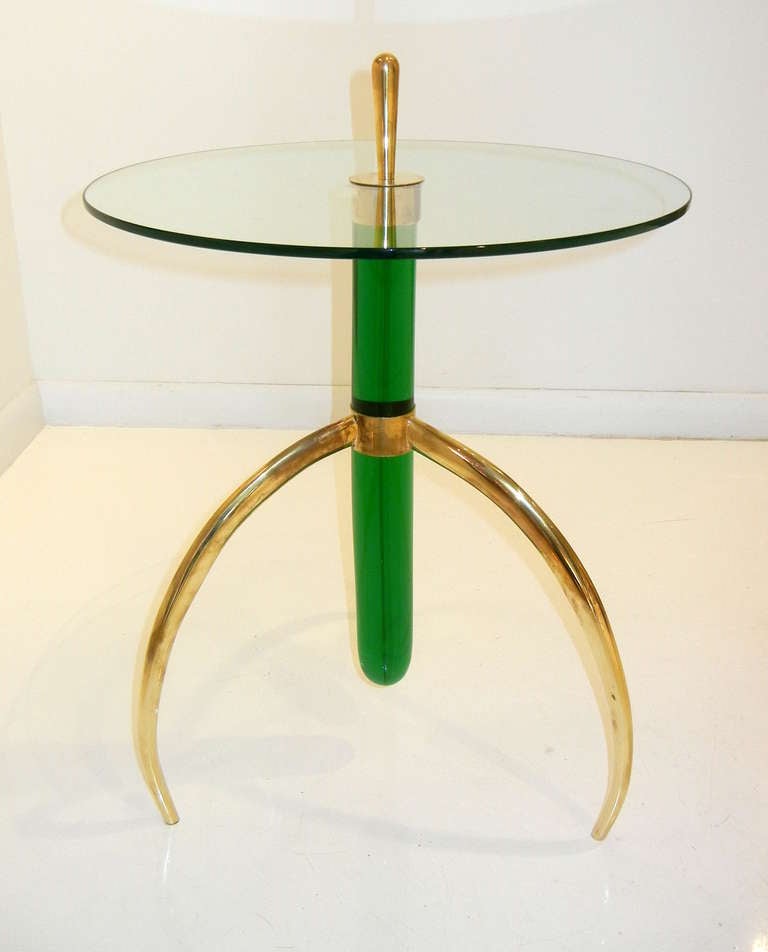 A pair of Italian side or end tables, the circular glass top pierced with a large brass finial connecting a thick emerald green Murano glass column set into a brass tripod base.