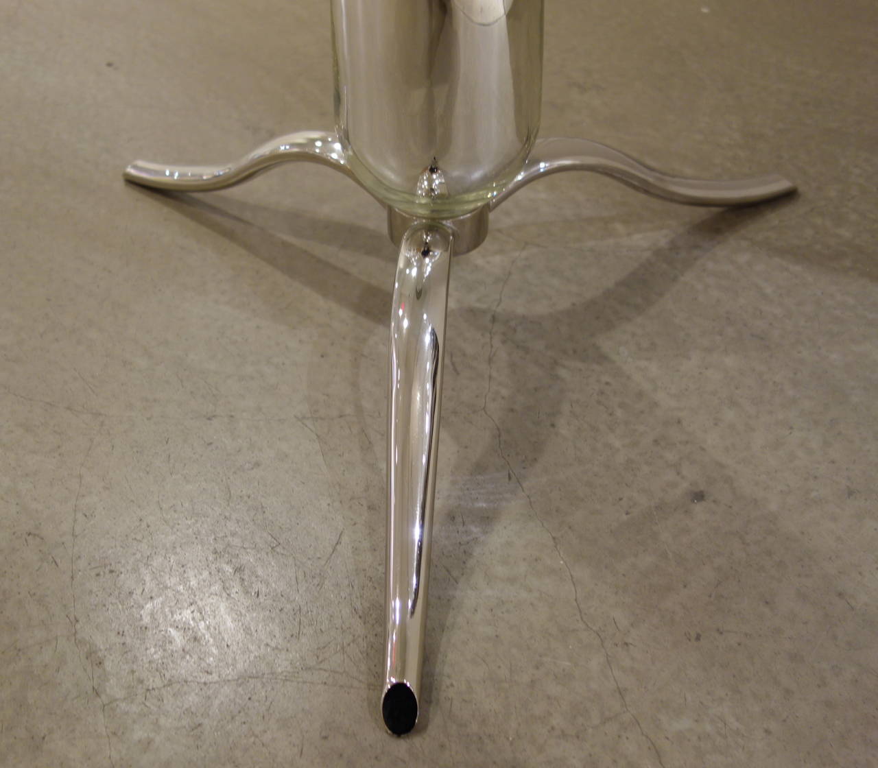 A Mid-Century Italian side or end table with clear glass circular top pierced with a large chrome finial with a mirrored tapered conical base resting on a chrome tripod base.