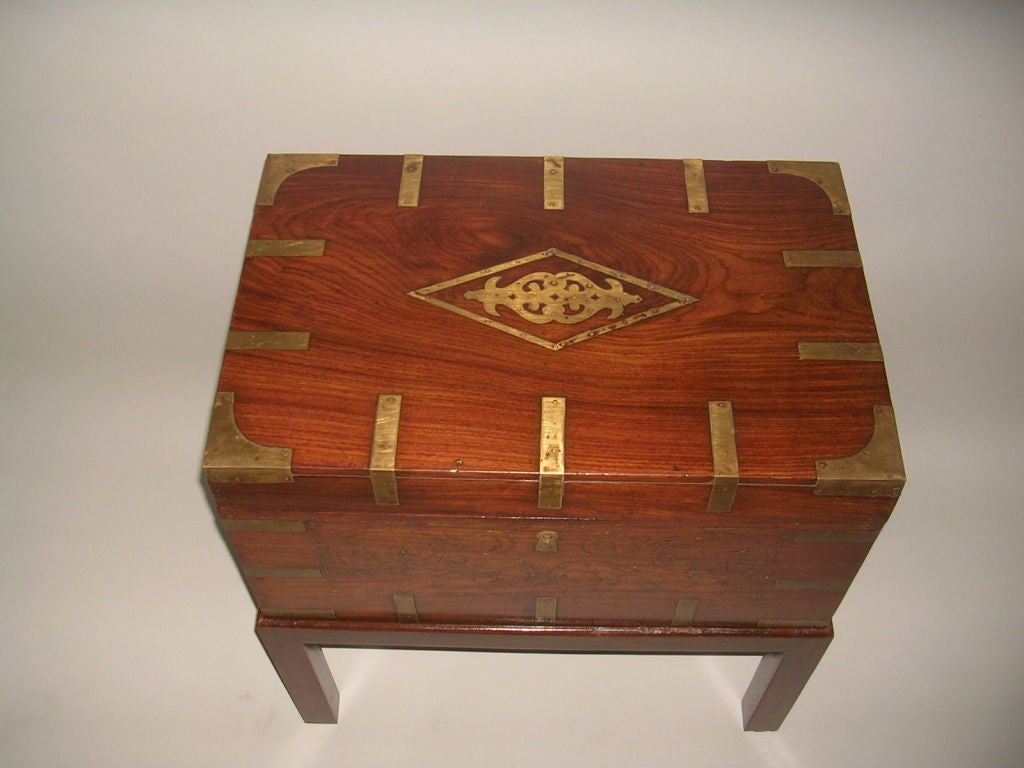 A 19th century Anglo-Indian rosewood document box, the top with central diamond shaped medallion of brass inlay with brass corners and bindings on each side, the front panel with design of brass stringing, repeated on the fitted interior with