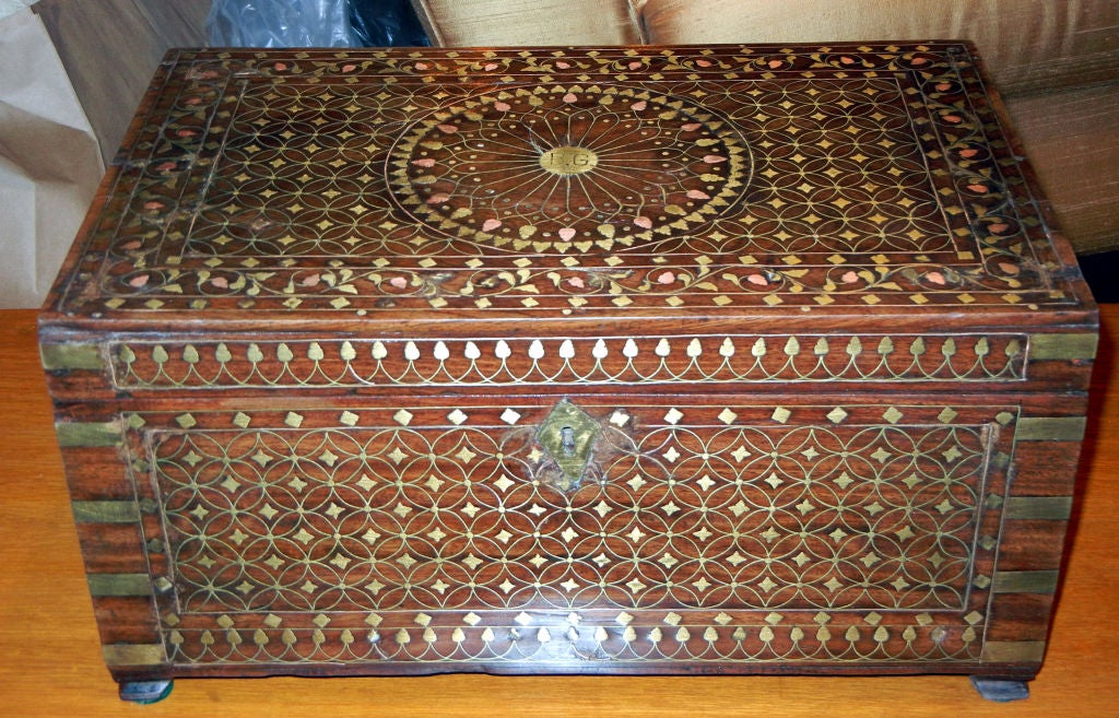 A 19th century Anglo-Indian rosewood box with allover brass and copper inlay with brass side bindings, the top with a central circular medallion, the center with the initials, 