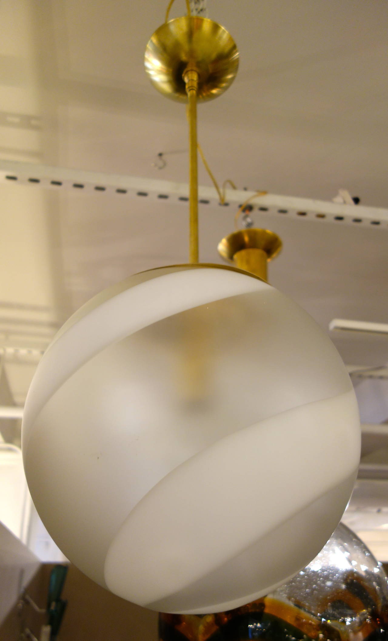 Un lustre/pendentif italien du milieu du siècle, soufflé à la main à Murano, le globe en verre composé de larges spirales d'un design alternant le clair et le blanc opaque, suspendu à un poteau en laiton avec un baldaquin sur mesure nouvellement
