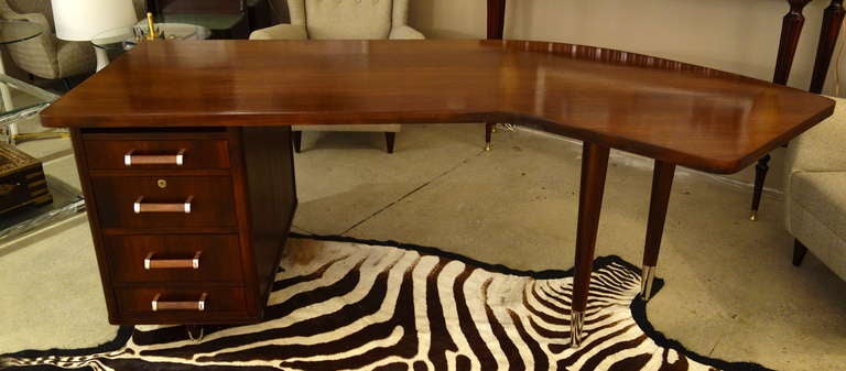 A Mid-Century American Cherry and Walnut 77 inch executive desk with a slight
boomerang top resting on a 4 drawer cabinet and two conical, tapered
legs with replated nickel fittings.

Keywords Search: 1stdibs, 1stdibs.com, desk, executive desk