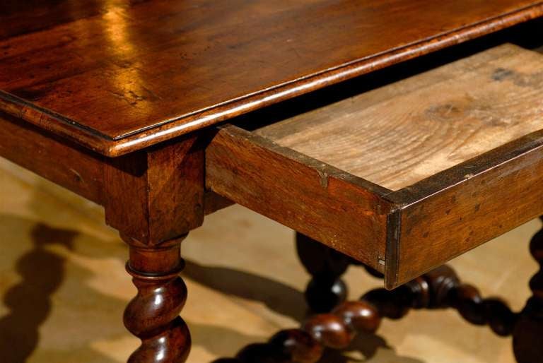 A French 17th century period Louis XIII walnut side table with single drawer and barley-twist base. This French side table features a rectangular planked top with rounded edges sitting above a simple apron comprising a single long drawer, opening