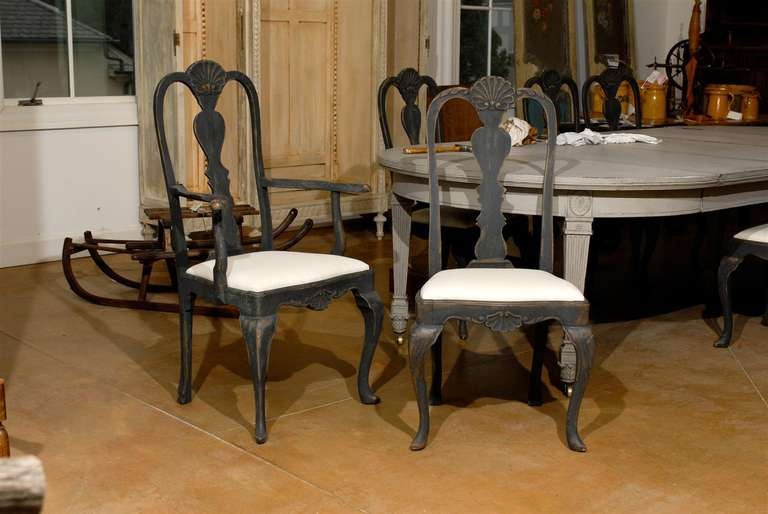 A set of eight Swedish Rococo Revival painted dining room chairs from the mid 19th century with newly upholstered seats. This set of Scandinavian dining chairs features six sides and two armchairs. Each chair comprises a pierced back, adorned with a