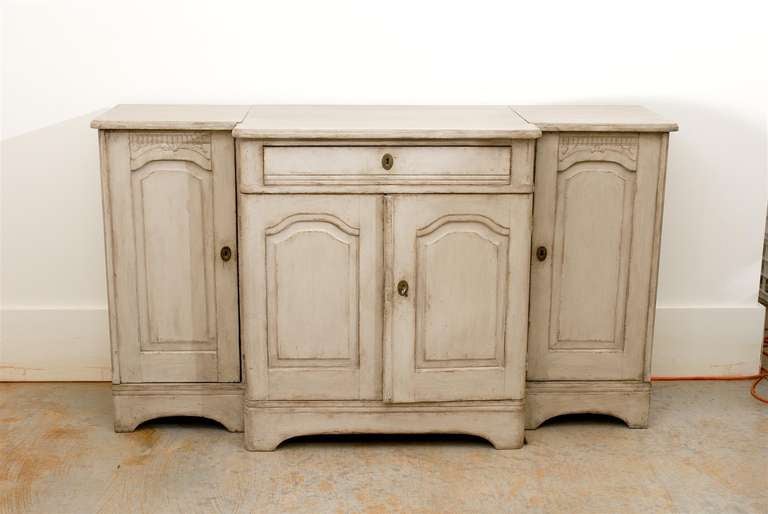 A Swedish painted wood breakfront enfilade with single drawer and four doors from the early 19th century. This Swedish long buffet features a shaped top sitting above a single drawer and two lateral cabinets. The protruding facade also receives a