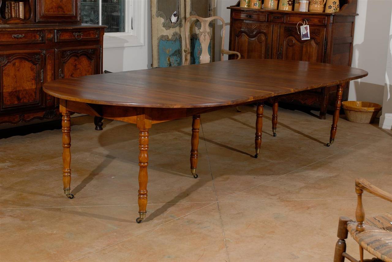 19th century walnut extension table with four leaves. Each leaf approximately 18.25 inches wide. Table is 45.5