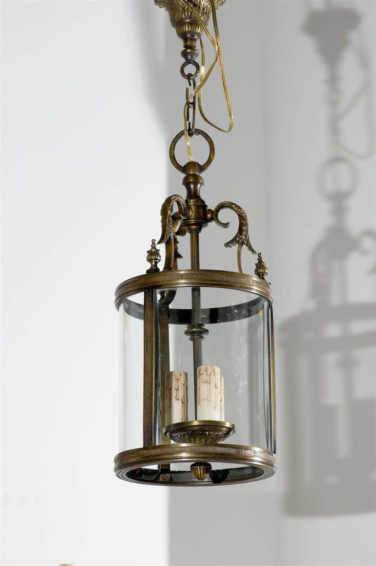 A French Louis XVI style bronze three-light circular lantern from the early 19th century, with glass panels. Born in France during the early years of the 19th century, this lovely Louis XVI style lantern features a bronze armature accented with