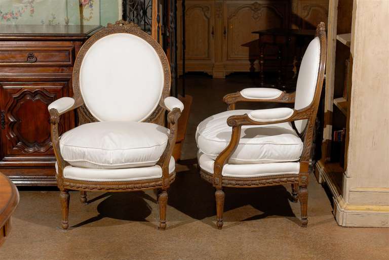 Carved Pair of French Louis XVI Style Upholstered Armchairs from the Early 19th Century
