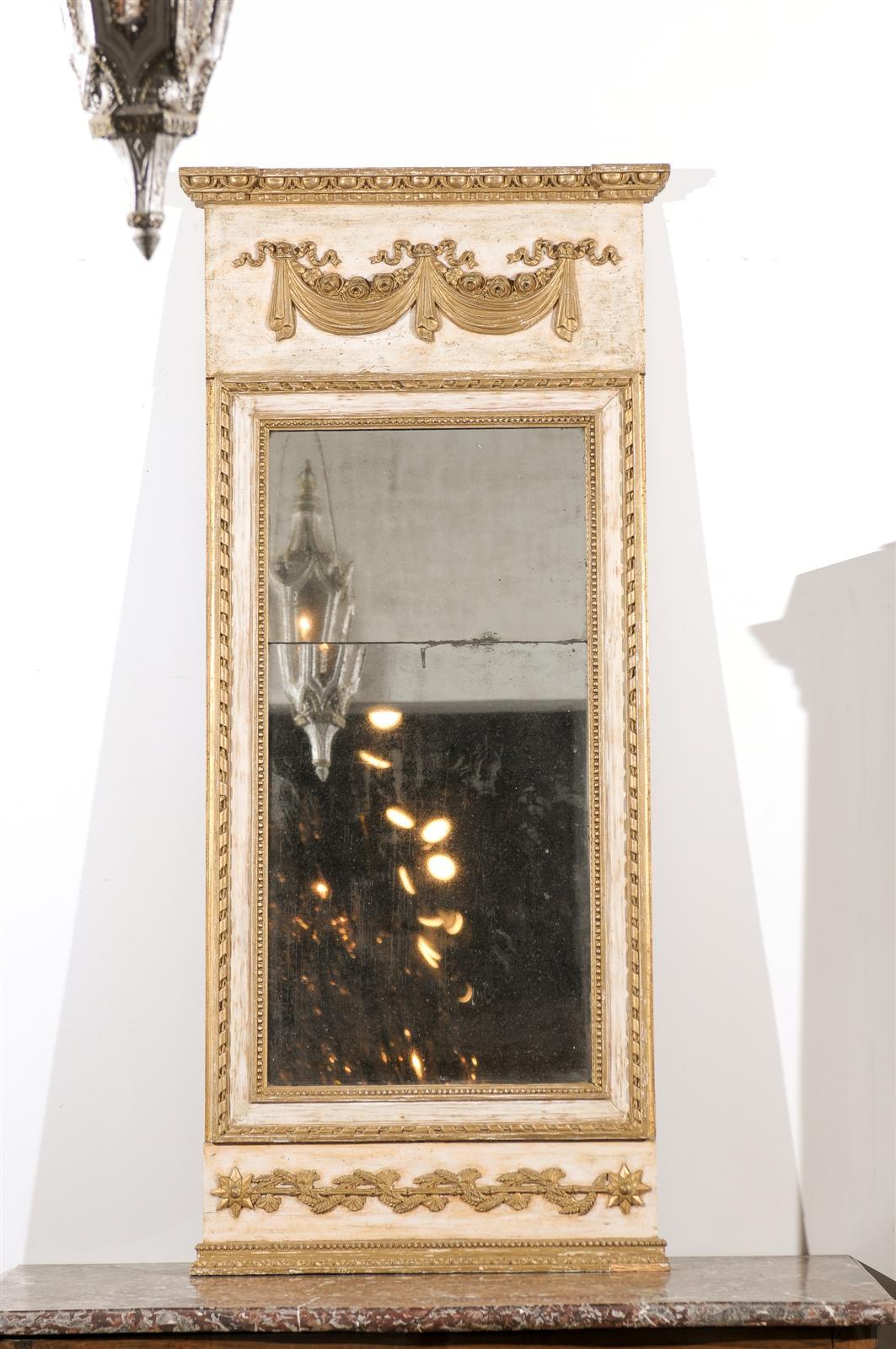 A Swedish period Gustavian painted and gilt trumeau mirror from the late 18th century with original paint and original split mercury glass. This exquisite Swedish trumeau mirror features a slender linear Silhouette, beautifully adorned with gilt
