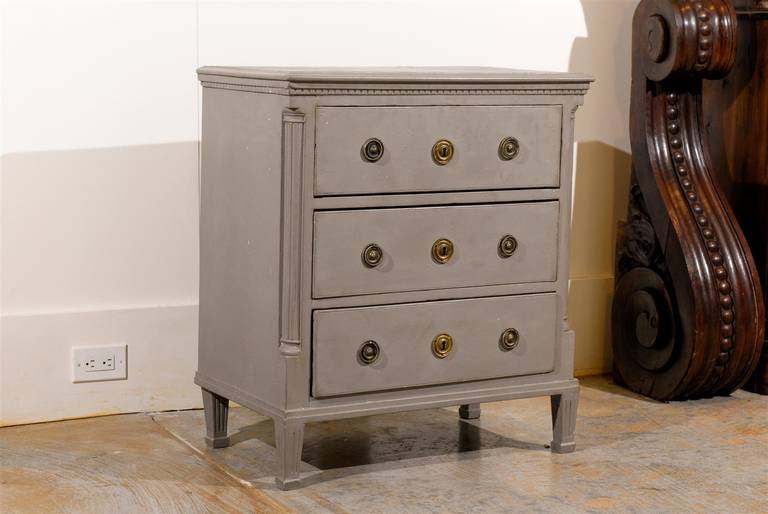 A Swedish Gustavian period painted wooden three-drawer chest with original hardware from the 1790s. This petite Swedish three-drawer commode features a black colored rectangular top sitting above a dentil molding, typical of the Gustavian era. Three