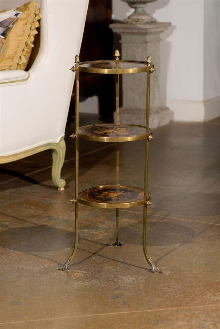 A French brass three-tiered étagère with marquetry décor from the second half of the 19th century. This French étagère features three circular shelves, each adorned with an exquisite marquetry décor. The upper and lower levels are decorated with