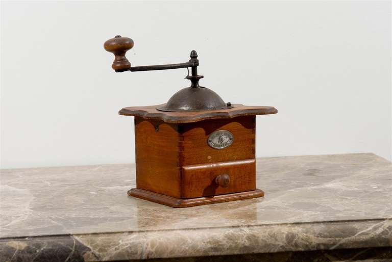 Macinacaffè francese rustico in legno della fine del XIX secolo, con piano sagomato, manico in verde e piccolo cassetto. Creato in Francia nell'ultimo quarto del XIX secolo, questo piccolo macinino ci affascina per il suo aspetto semplice. Presenta