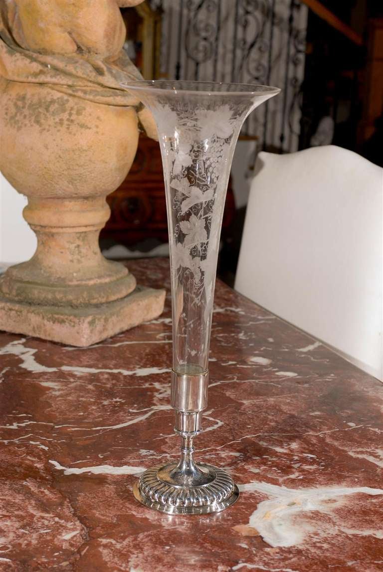 A tall English etched mouth blown glass flower vase mounted on sterling silver base with floral motifs from the late 19th century. This thin flower vase features a delicate blown glass body with wide lip, adorned with foliage and fruit motifs etched