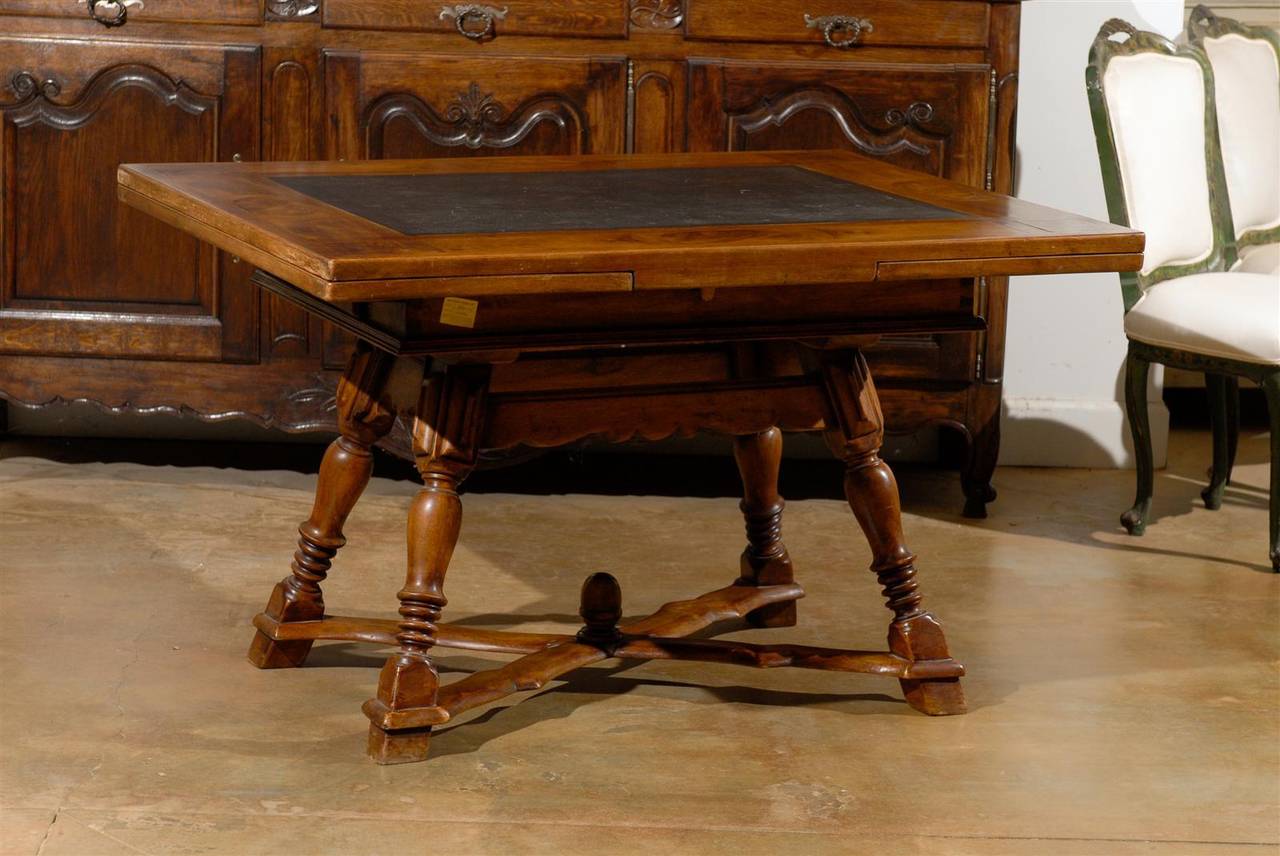 19th century French walnut draw-leaf table with inset slate top. Two side drawers, carved apron. Extends to 84 inches.