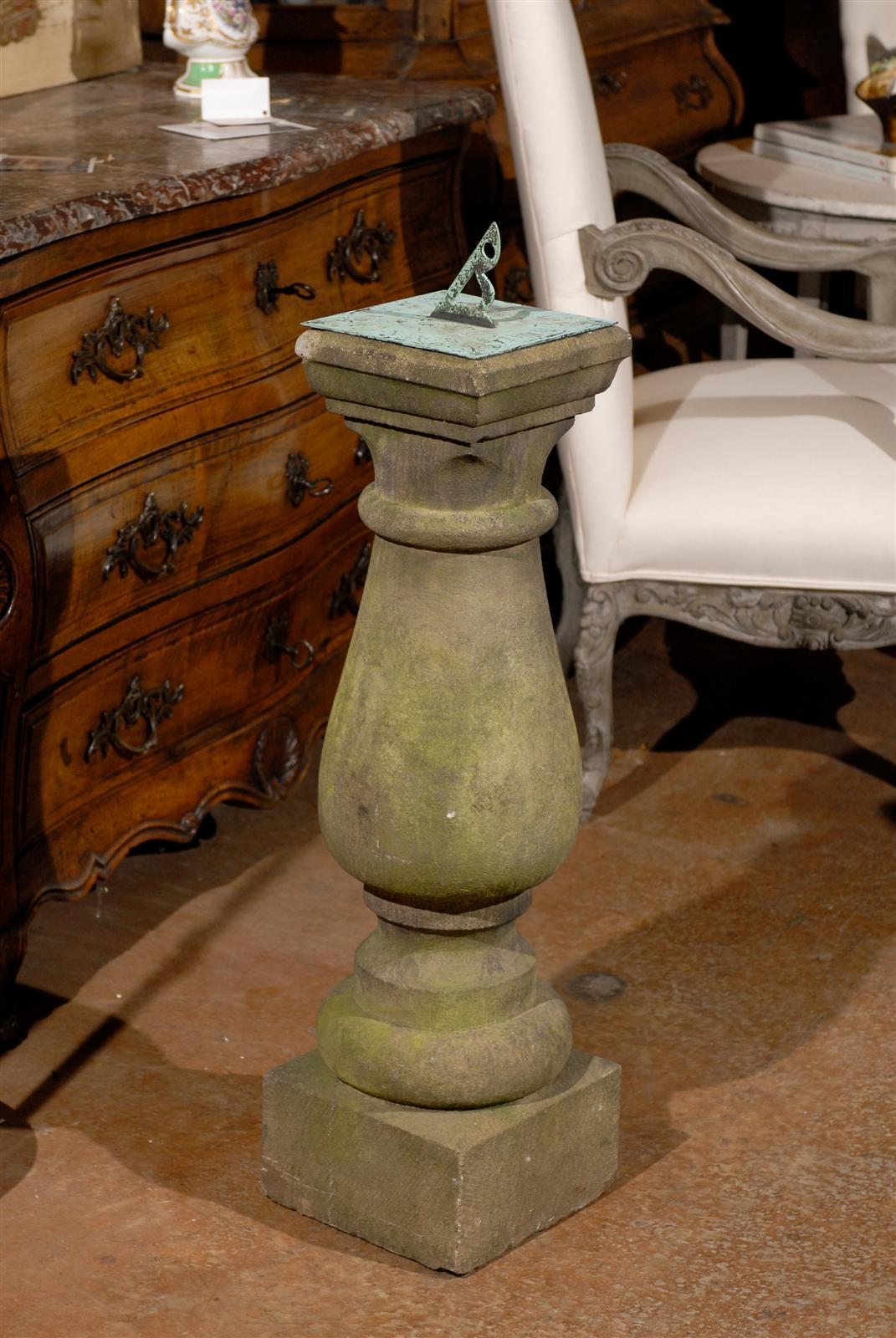 An English sandstone baluster-shaped sundial with bronze dial from the mid 19th century. This English sundial features a lovely baluster shape, topped with a bronze dial revealing a lovely verdigris, an exquisite green patina, typical of