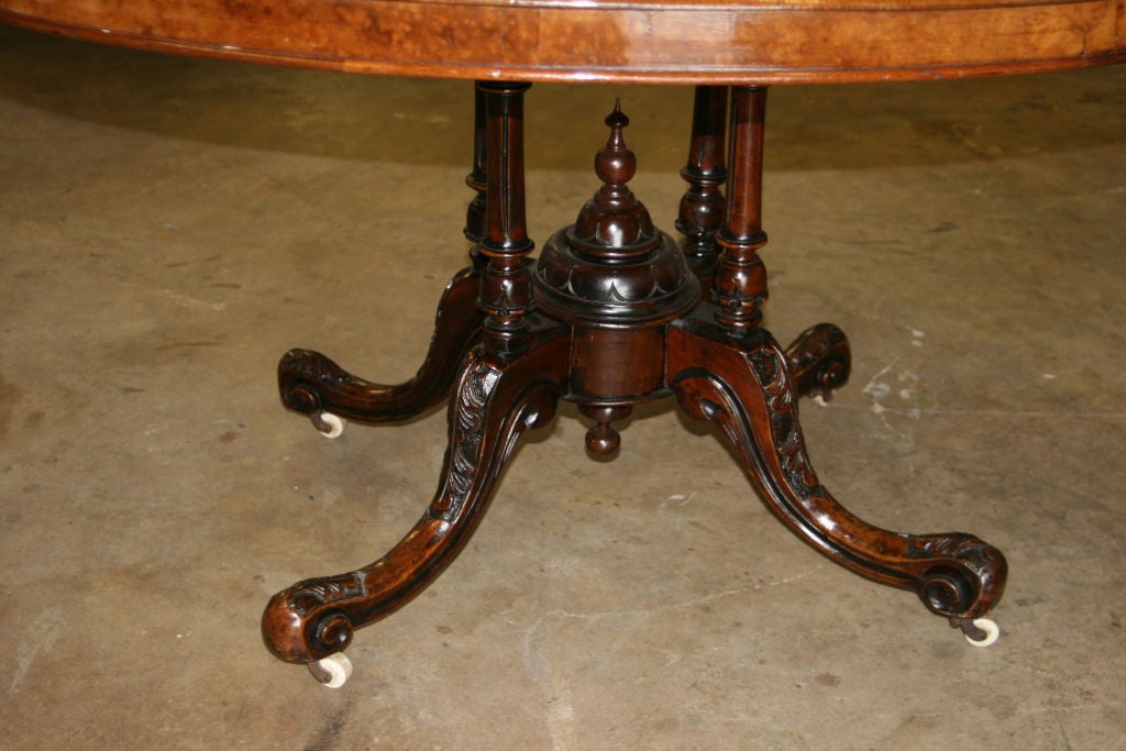 Burl Walnut Oval Tilt Top 'Loo' Table. Great Patina. Original porcelain casters. Hand carved pedestal.