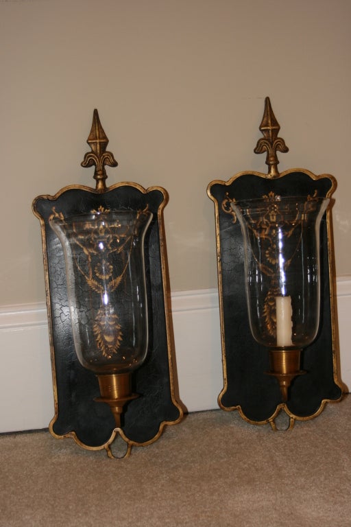 Pair of French wall sconce, candle holders.  'Distressed' look.  Black & Gold painted background with brass and glass candle globes.  Feature Fleur de lis theme.  Very good looking.
