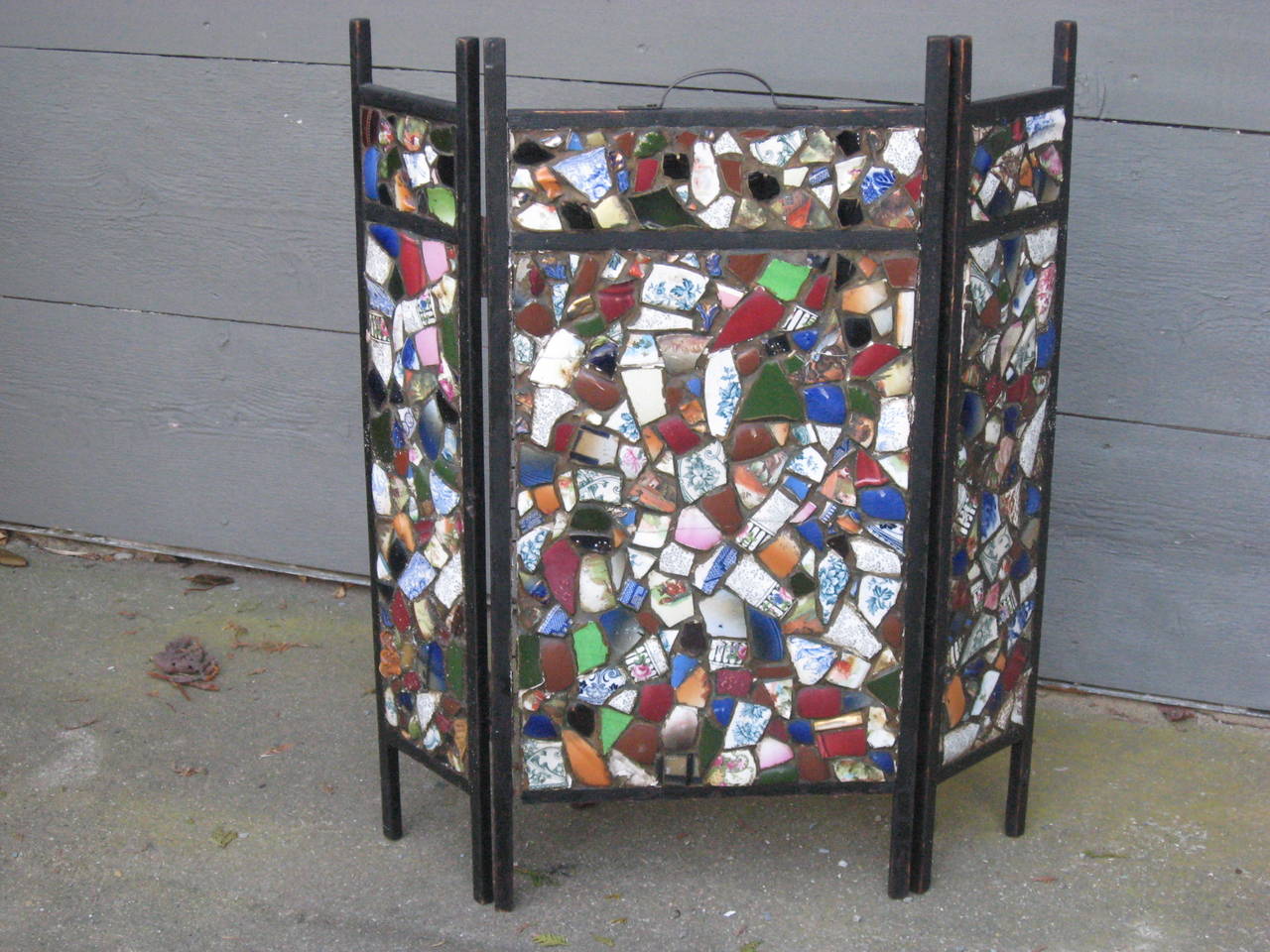 American 19th-early 20th century Mosaic ( handmade from broken antique dish pieces). Tramp Art folding fire screen with handle.
Measures: 27.5". Each side 6". Center 13".