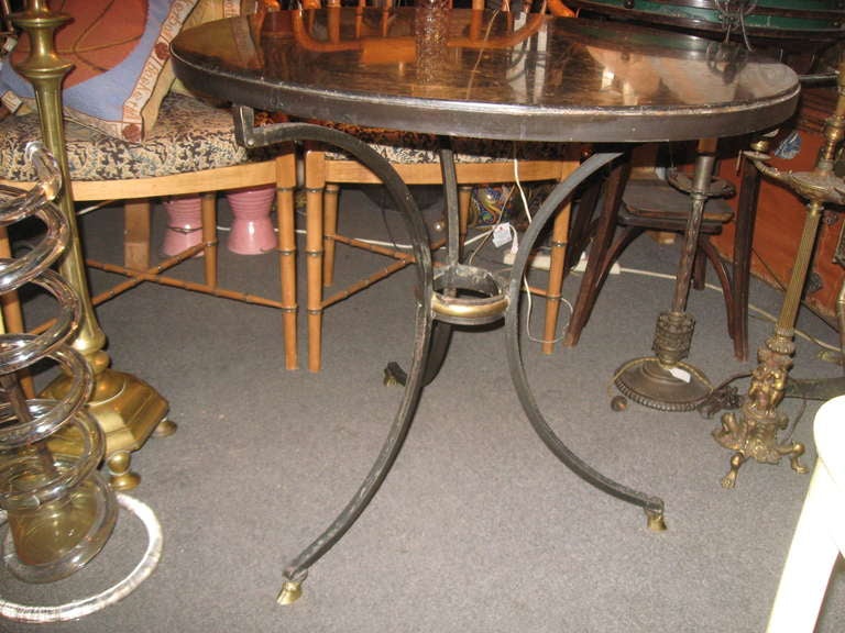 Iron, marble gueridon table with bronze hooves feet.