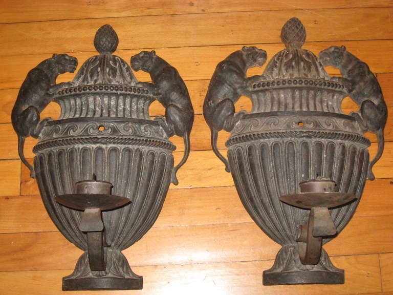 Pair of neoclassical style iron sconces with leopards.