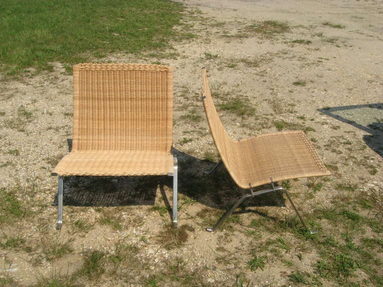 Vintage pair of brushed stainless steel and wicker lounge chairs by Poul Kjaerholm.