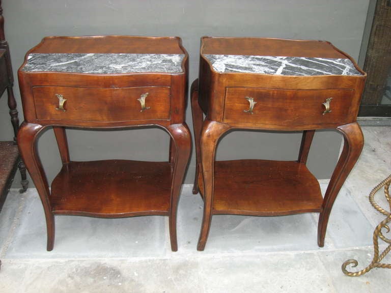 Pair of fruitwood end tables/nightstands with marble inserts and brass pulls.
Top length 19.5