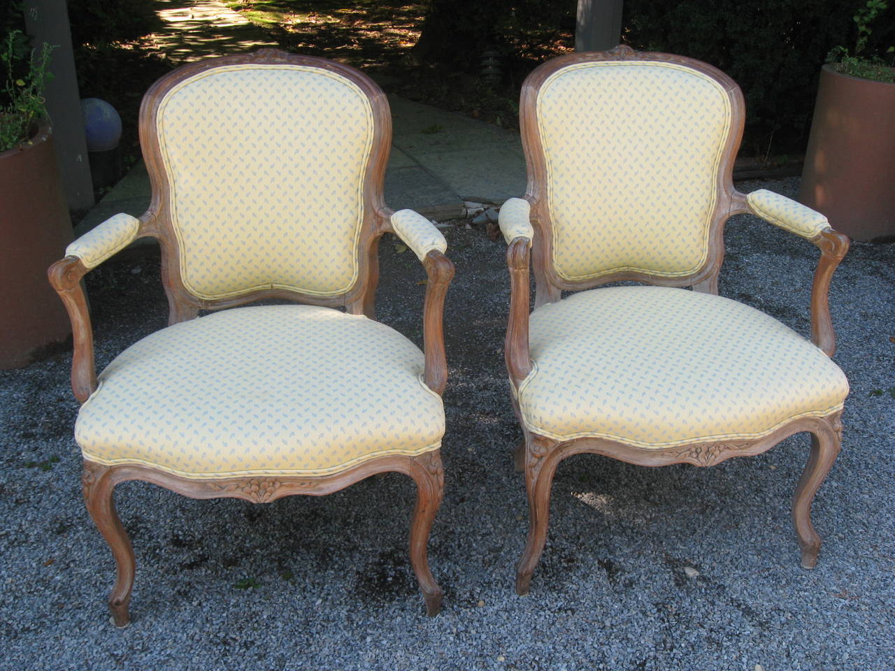 Pair of Louis XV style armchairs in natural wood and custom cotton upholstery with two additional matching pillows.