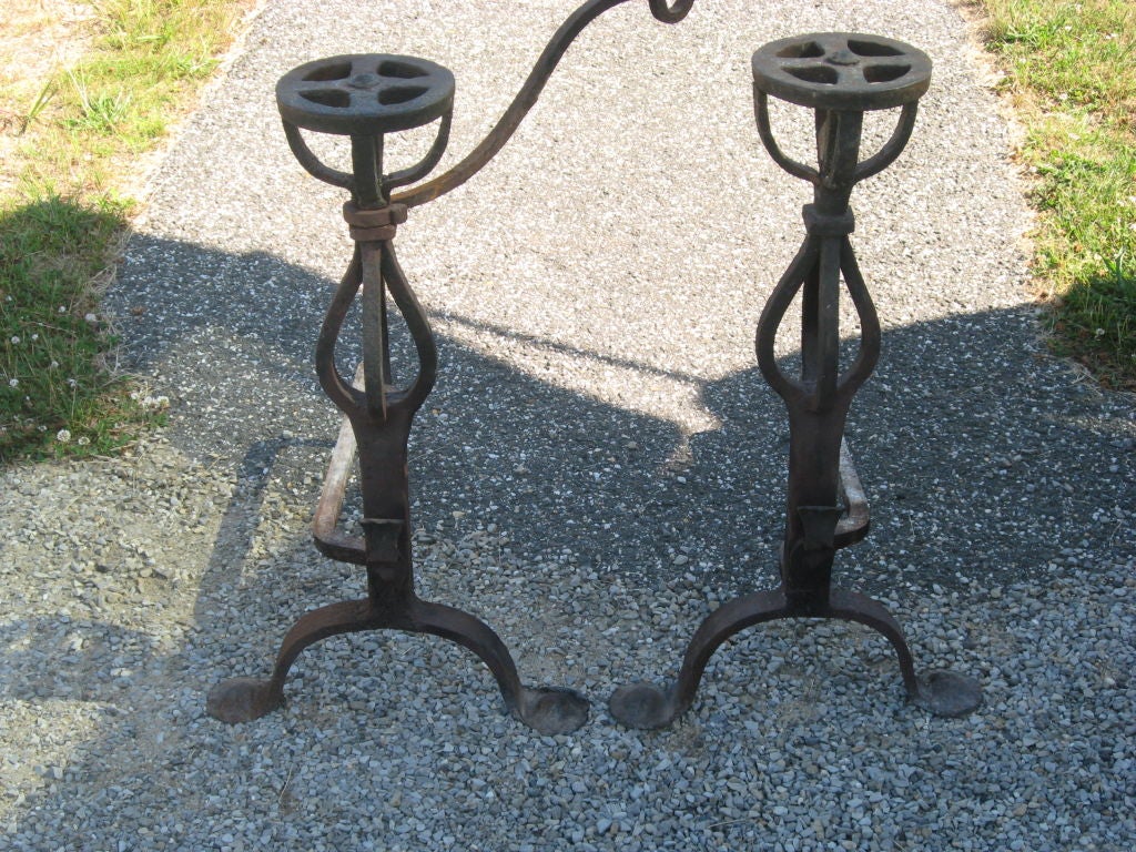 Vintage pair of hand-forged iron andirons with pot holder.